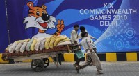 Workers in front of Commonwealth Game sign http://www.msnbc.msn.com/id/39320649/ns/world_news-south_and_central_asia/