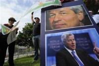 Protestors hold signs as JP Morgan Chase & Co convenes its annual shareholders meeting at the bank's back-office complex in Tampa, Florida