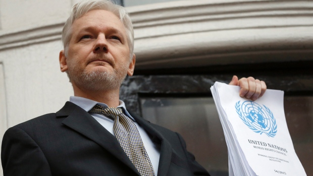 WikiLeaks founder Julian Assange holds a UN report as he speaks on the balcony of the Ecuadorean Embassy in London on Friday. (Frank Augstein/Associated Press)