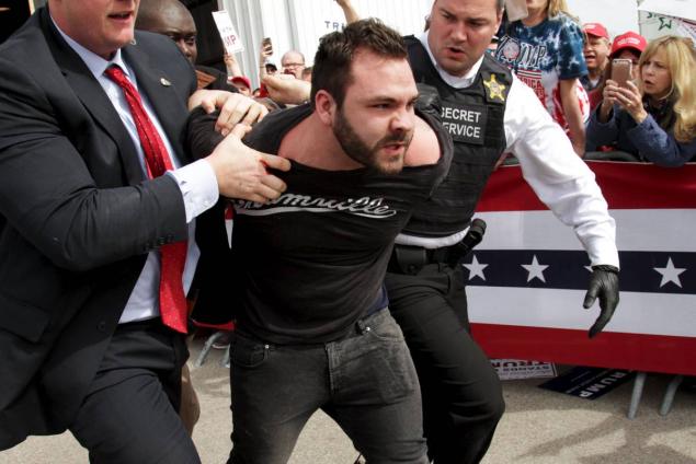 WILLIAM PHILPOTT/REUTERS Authorities detain a protester on Saturday at Trump's rally in Dayton, Ohio.