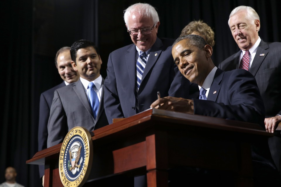 Senator Bernie Sanders watches as President Obama signs the Veterans' Access to Care through Choice, Accountability, and Transparency Act of 2014. Jacquelyn Martin/AP