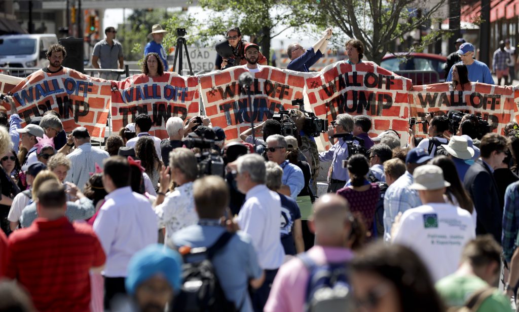 Immigrant rights activists hold up a fabric wall to protest against Republican presidential candidate Donald Trump, Wednesday, July 20, 2016, in Cleveland, during the third day of the Republican convention.(AP Photo/Patrick Semansky)