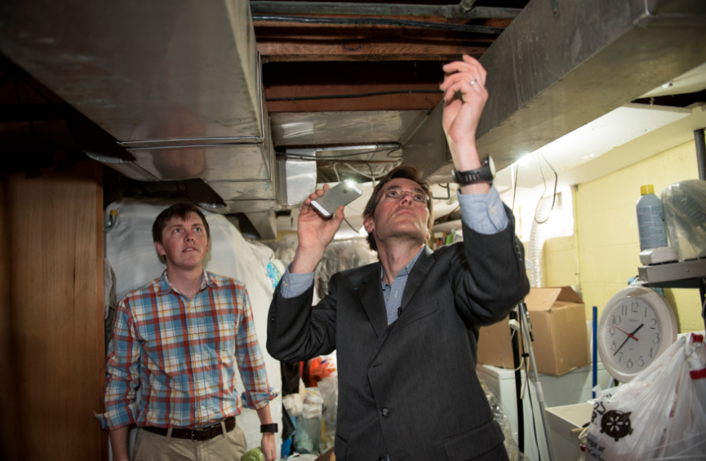 Dr. Marc Edwards and doctoral student William Rhoads (left) examine pipes in a home in Flint, Michigan.